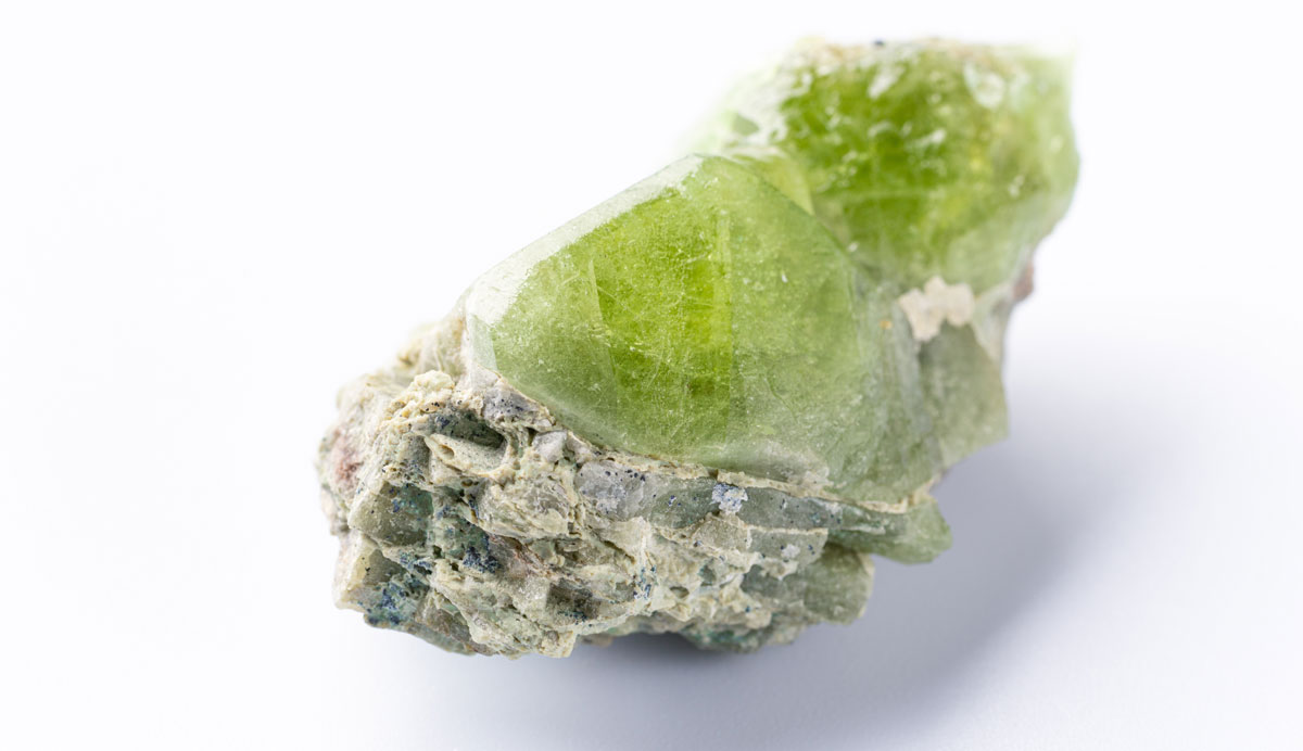 Roher Olivin-Kristall mit Gestein